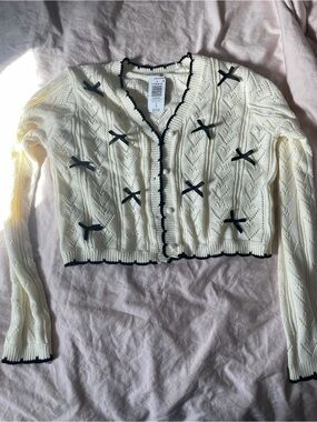 torrid LoveSick Bow Cream Knit Button-Up Cardigan with Black Trim & Bow Accents